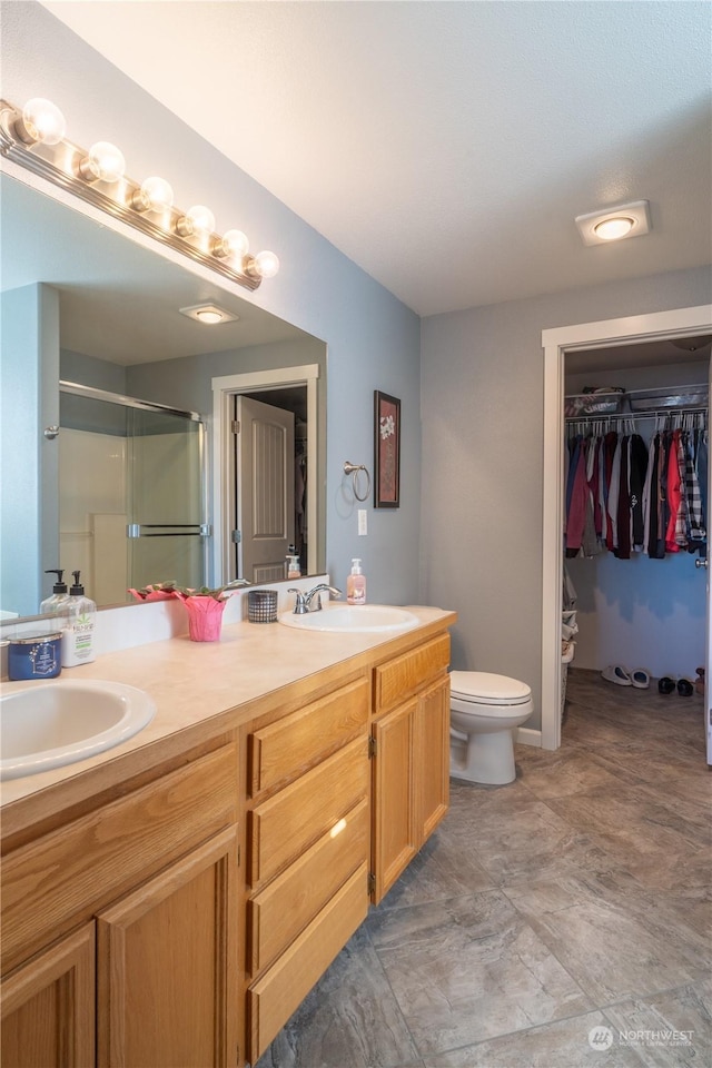 bathroom featuring an enclosed shower, vanity, and toilet