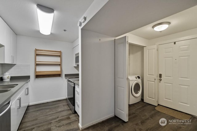 clothes washing area with sink, washer / dryer, and dark hardwood / wood-style floors