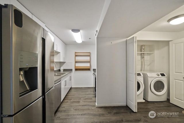 washroom featuring dark wood-type flooring, sink, and washing machine and clothes dryer