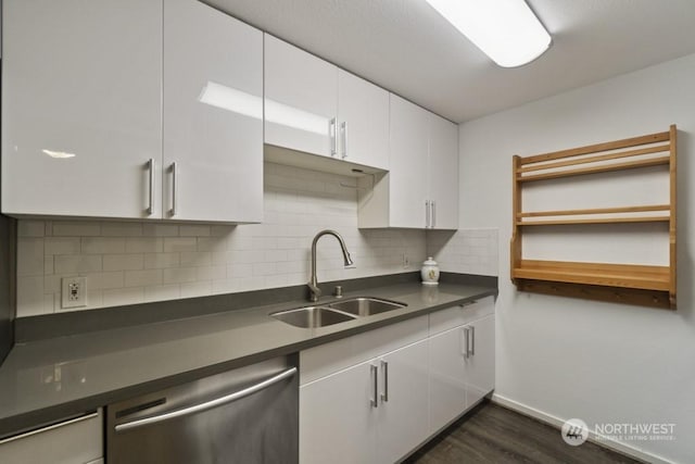 kitchen featuring dark wood-type flooring, sink, white cabinetry, dishwasher, and decorative backsplash