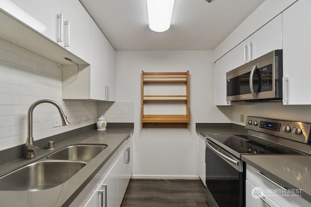 kitchen with tasteful backsplash, sink, stainless steel appliances, and white cabinets