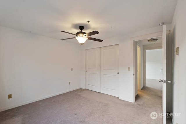 unfurnished bedroom with light colored carpet, ceiling fan, and a closet