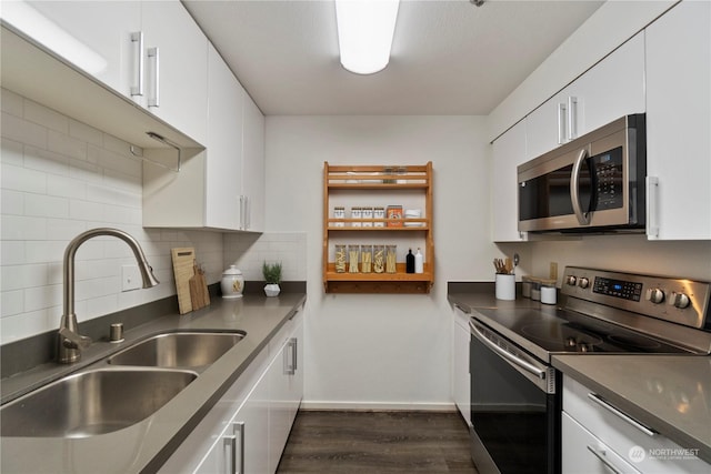 kitchen with sink, backsplash, white cabinets, and appliances with stainless steel finishes