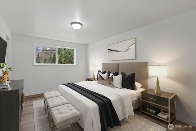 bedroom with baseboards and wood finished floors