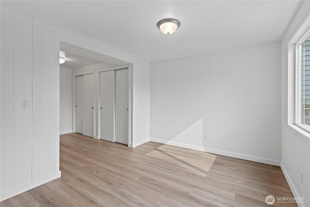 empty room with light wood finished floors and baseboards