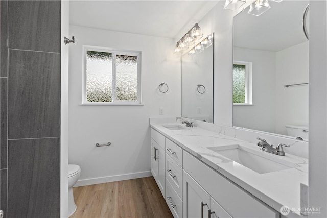 bathroom featuring plenty of natural light, toilet, and a sink