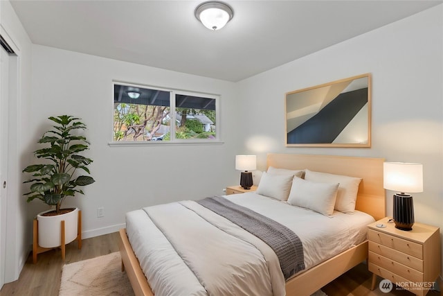 bedroom with baseboards and wood finished floors