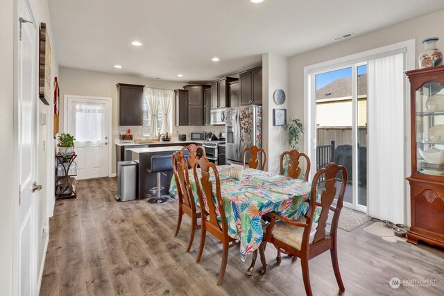 dining room with plenty of natural light and light hardwood / wood-style flooring