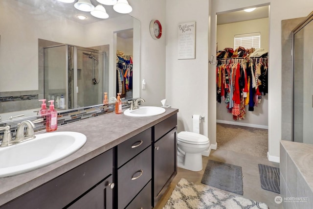 bathroom with toilet, vanity, and a shower with door