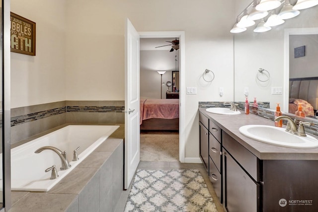 bathroom with ceiling fan, vanity, and a relaxing tiled tub