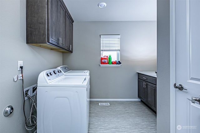 laundry area featuring separate washer and dryer and cabinets