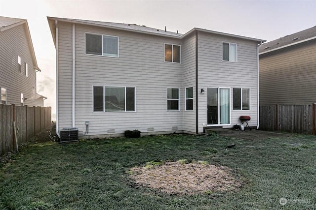 rear view of house with a yard and central air condition unit