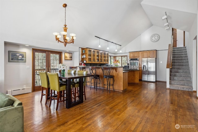 dining area featuring a baseboard heating unit, french doors, high vaulted ceiling, an inviting chandelier, and dark wood-type flooring