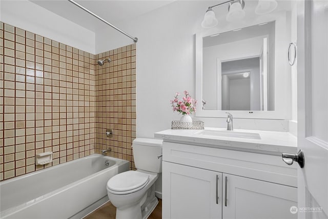 full bathroom featuring toilet, vanity, and tiled shower / bath