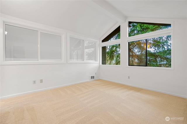 carpeted empty room featuring vaulted ceiling with beams