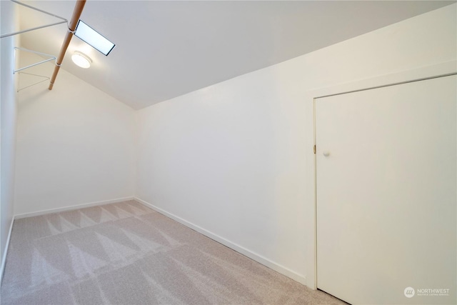 bonus room with light colored carpet and vaulted ceiling