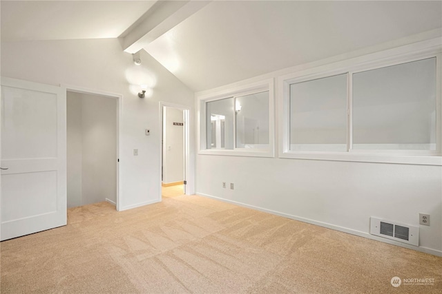 unfurnished bedroom with light colored carpet and vaulted ceiling with beams