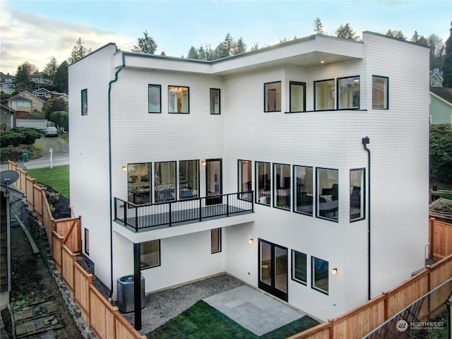 rear view of house with central AC unit and a patio area