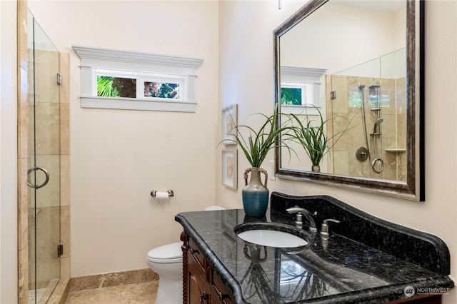 bathroom featuring toilet, tile patterned flooring, walk in shower, and vanity