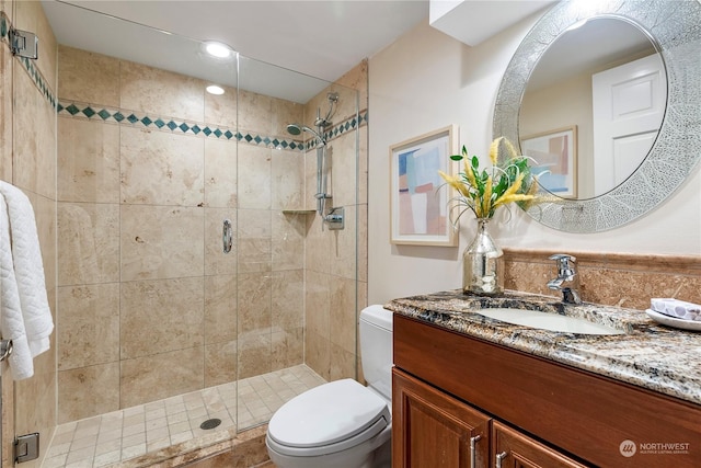 bathroom featuring an enclosed shower, vanity, and toilet