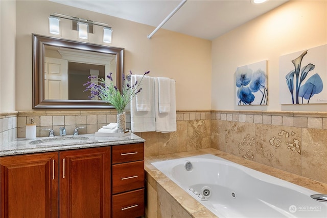 bathroom featuring tiled bath and vanity