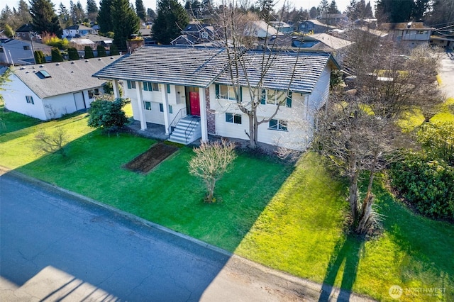 view of front of property featuring a residential view, stucco siding, and a front lawn