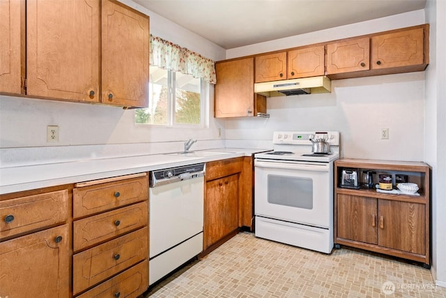 kitchen featuring white appliances, a sink, light countertops, under cabinet range hood, and brown cabinets