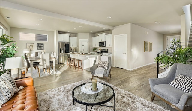 living room with sink and light hardwood / wood-style flooring