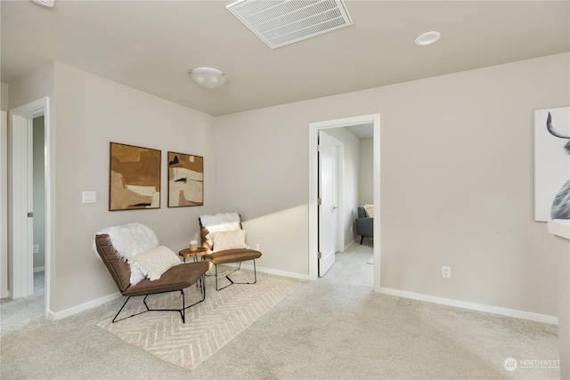 sitting room featuring light colored carpet