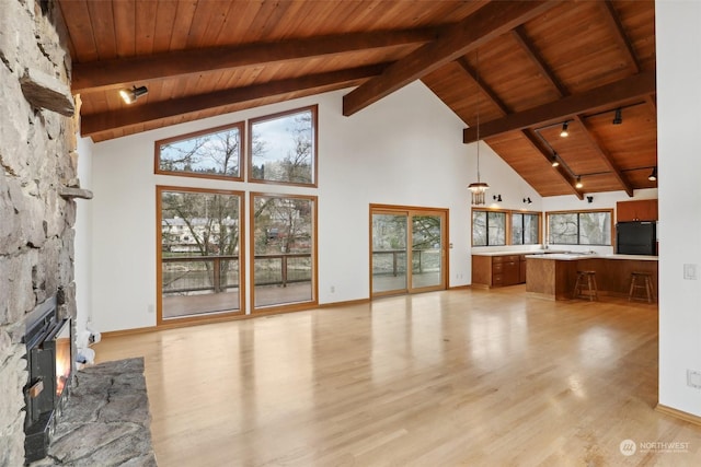 unfurnished living room featuring light wood-type flooring, wooden ceiling, and high vaulted ceiling