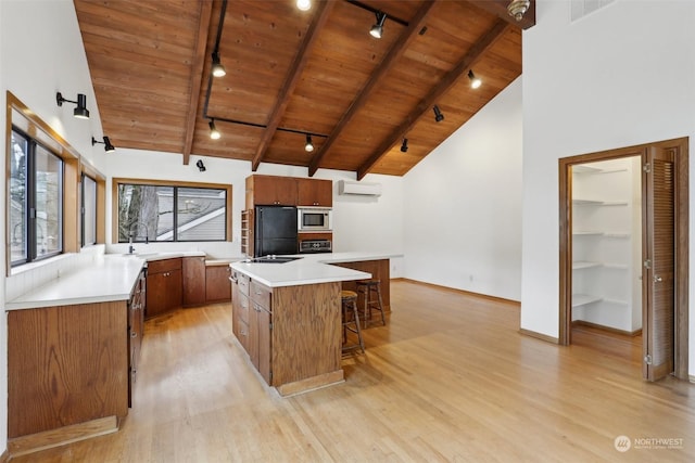 kitchen featuring a kitchen island, stainless steel microwave, wooden ceiling, and beam ceiling