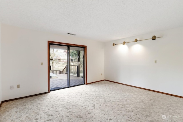 unfurnished room with carpet floors and a textured ceiling