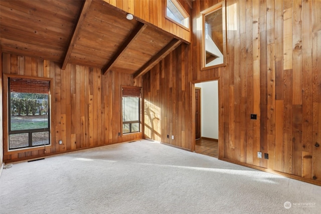 unfurnished living room with carpet floors, vaulted ceiling with beams, wooden walls, and wood ceiling