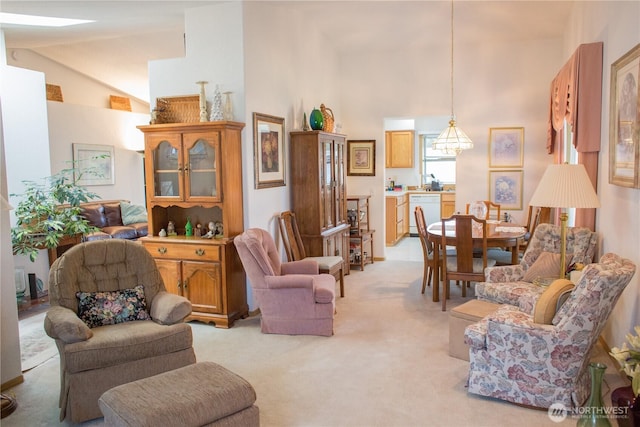 living area with light carpet and high vaulted ceiling