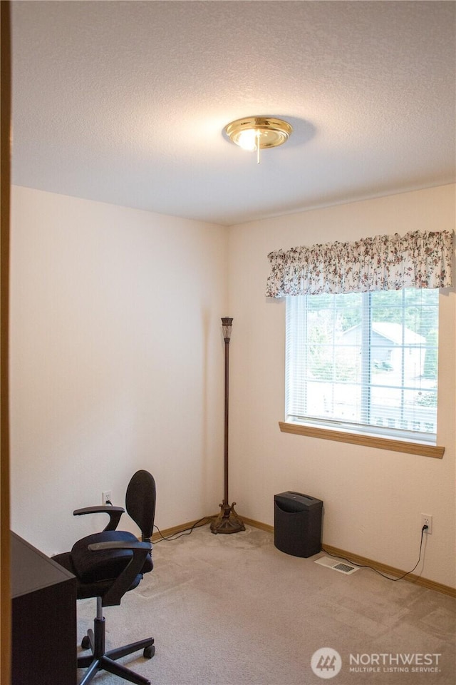 office with baseboards, a textured ceiling, visible vents, and carpet flooring