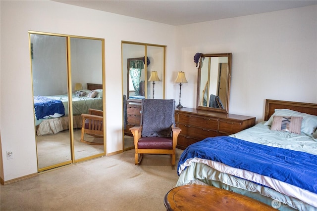 bedroom featuring carpet flooring, baseboards, and two closets