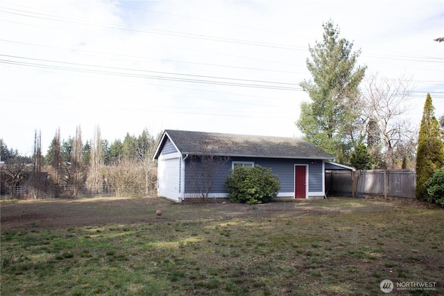 exterior space featuring a garage, an outdoor structure, and fence