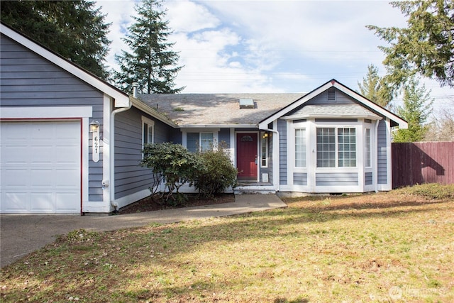 ranch-style home with a front yard, fence, and an attached garage