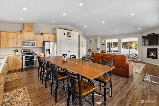 dining area featuring dark wood-type flooring and vaulted ceiling