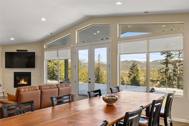 dining space featuring hardwood / wood-style flooring, lofted ceiling, and french doors