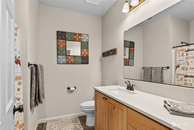 bathroom with vanity, hardwood / wood-style flooring, and toilet