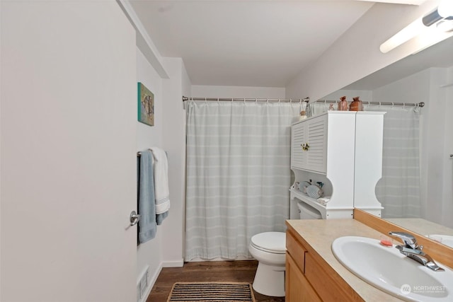 bathroom featuring vanity, hardwood / wood-style flooring, a shower with curtain, and toilet