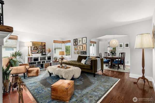 living room with baseboards, arched walkways, and wood finished floors