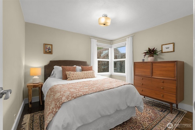 bedroom with baseboards and wood finished floors