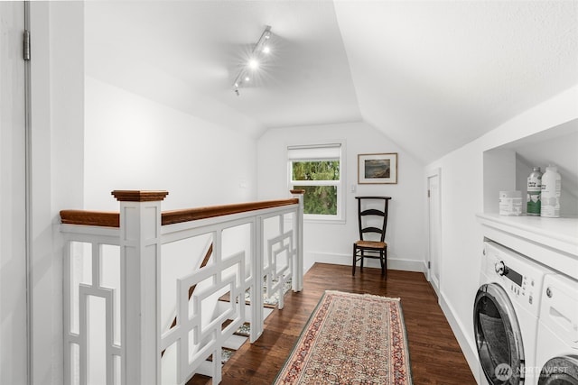 corridor featuring lofted ceiling, washer / clothes dryer, baseboards, and dark wood-style flooring