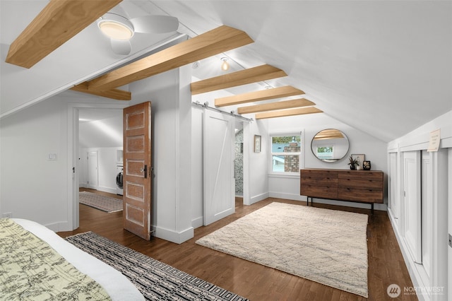 bedroom with a barn door, wood finished floors, baseboards, and vaulted ceiling