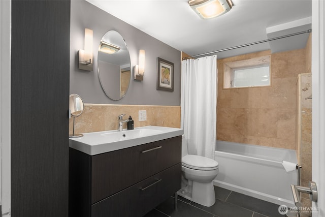 full bathroom with tile patterned flooring, toilet, vanity, shower / bath combination with curtain, and tile walls