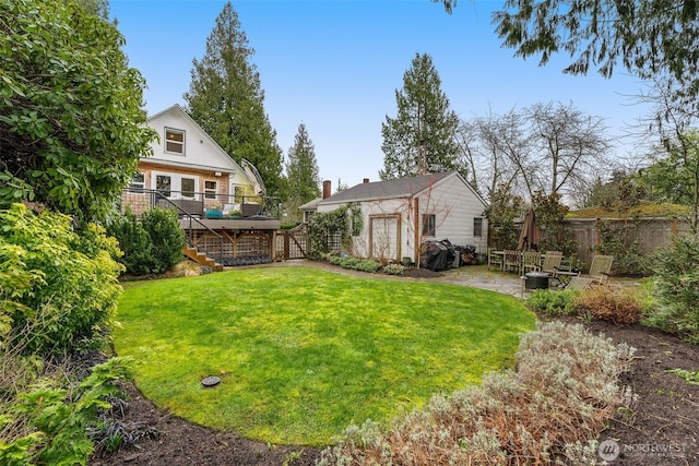 view of yard with a patio area, stairs, a deck, and fence