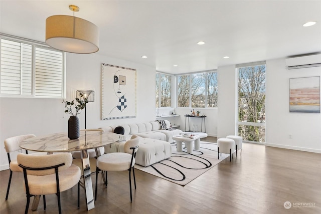 living room featuring a wall mounted air conditioner, a healthy amount of sunlight, and dark hardwood / wood-style flooring