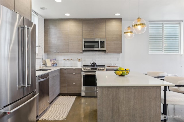 kitchen with decorative light fixtures, dark hardwood / wood-style flooring, stainless steel appliances, and tasteful backsplash